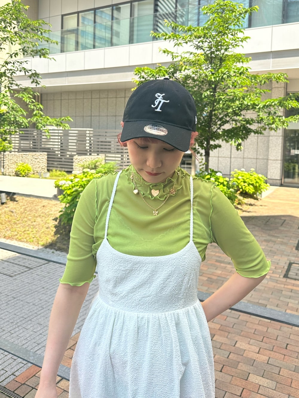 シルバー系のハンドバッグ、ブラック系のブーツ、ホワイト系のワンピースを着用したレディースの春コーディネートの4枚目の写真