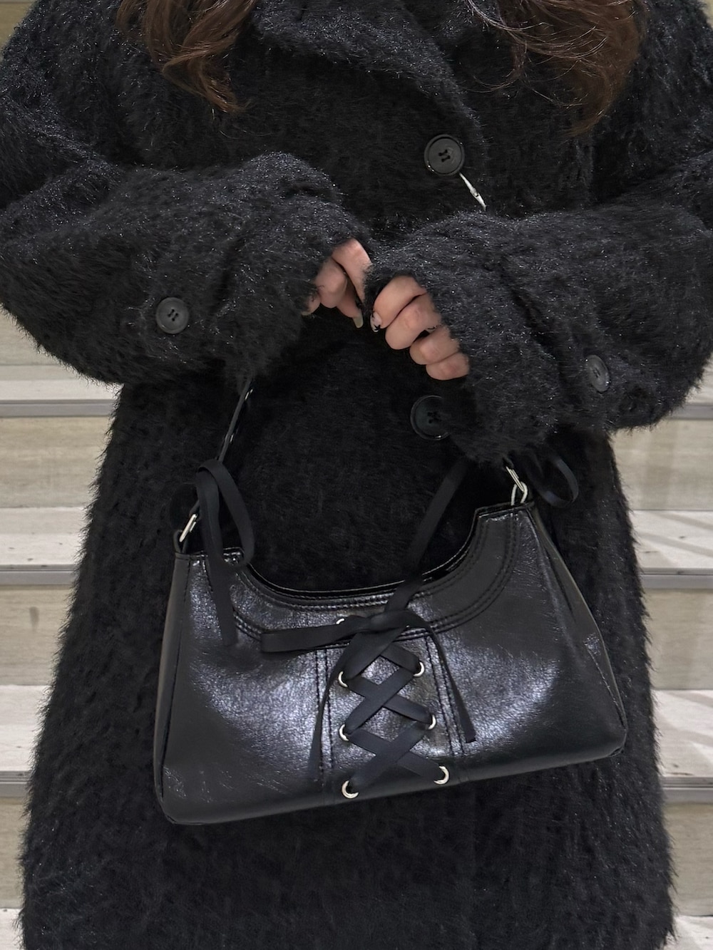 ブラック系のステンカラーコート、ブラック系のハンドバッグ、ブラック系のブーツを着用したレディースの冬コーディネートの8枚目の写真