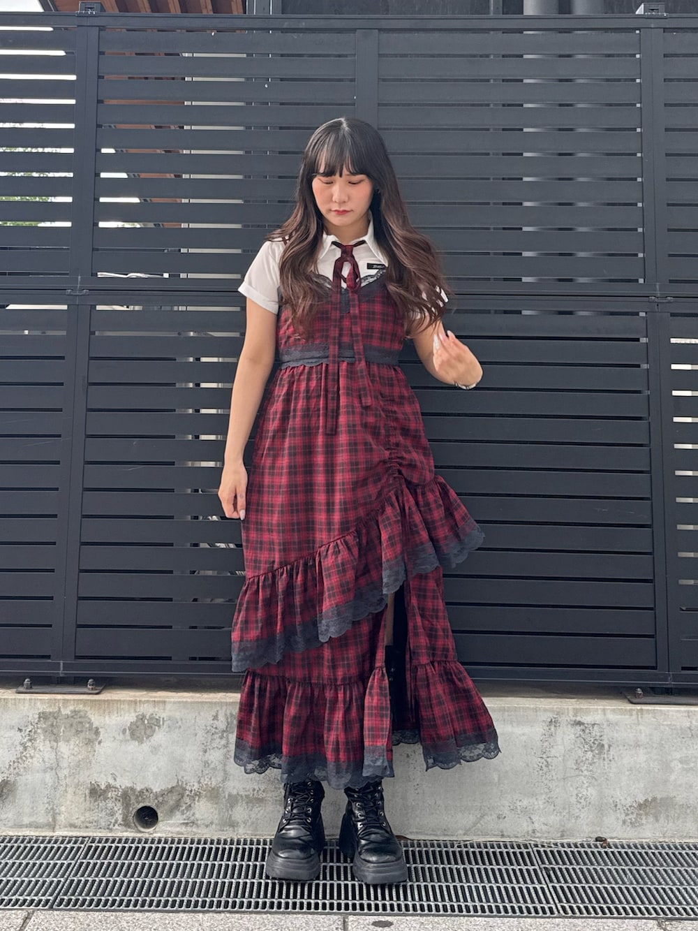 レッド系のワンピース、ブラック系のブーツ、ホワイト系のシャツ/ブラウスを着用したレディースの夏コーディネートの4枚目の写真