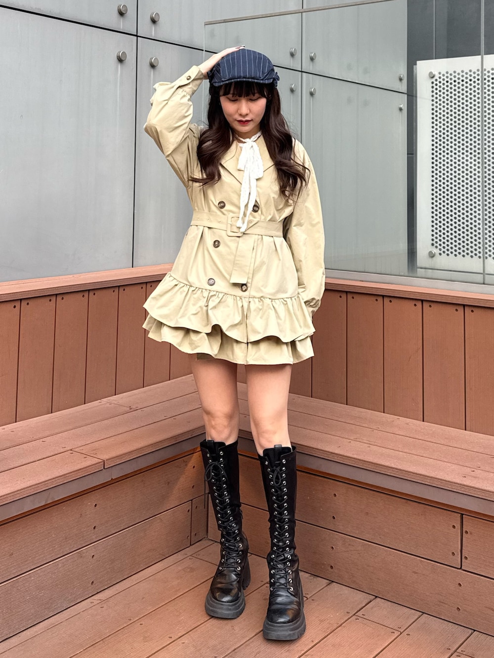 ベージュ系のワンピース、ホワイト系のTシャツ/カットソー、ブラック系のブーツを着用したレディースの冬コーディネートの2枚目の写真