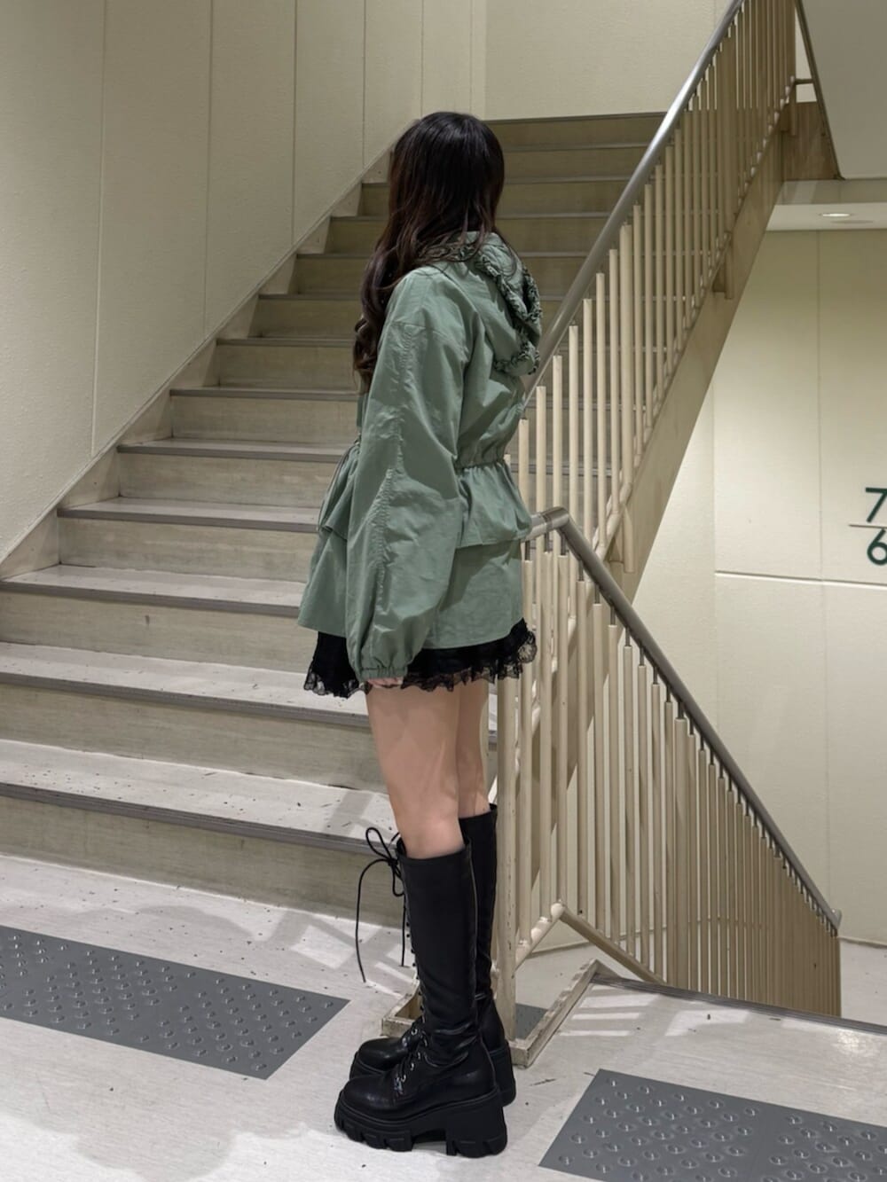 ブラック系のブーツ、グリーン系のナイロンジャケット、ブラック系のその他パンツを着用したレディースの春コーディネートの4枚目の写真