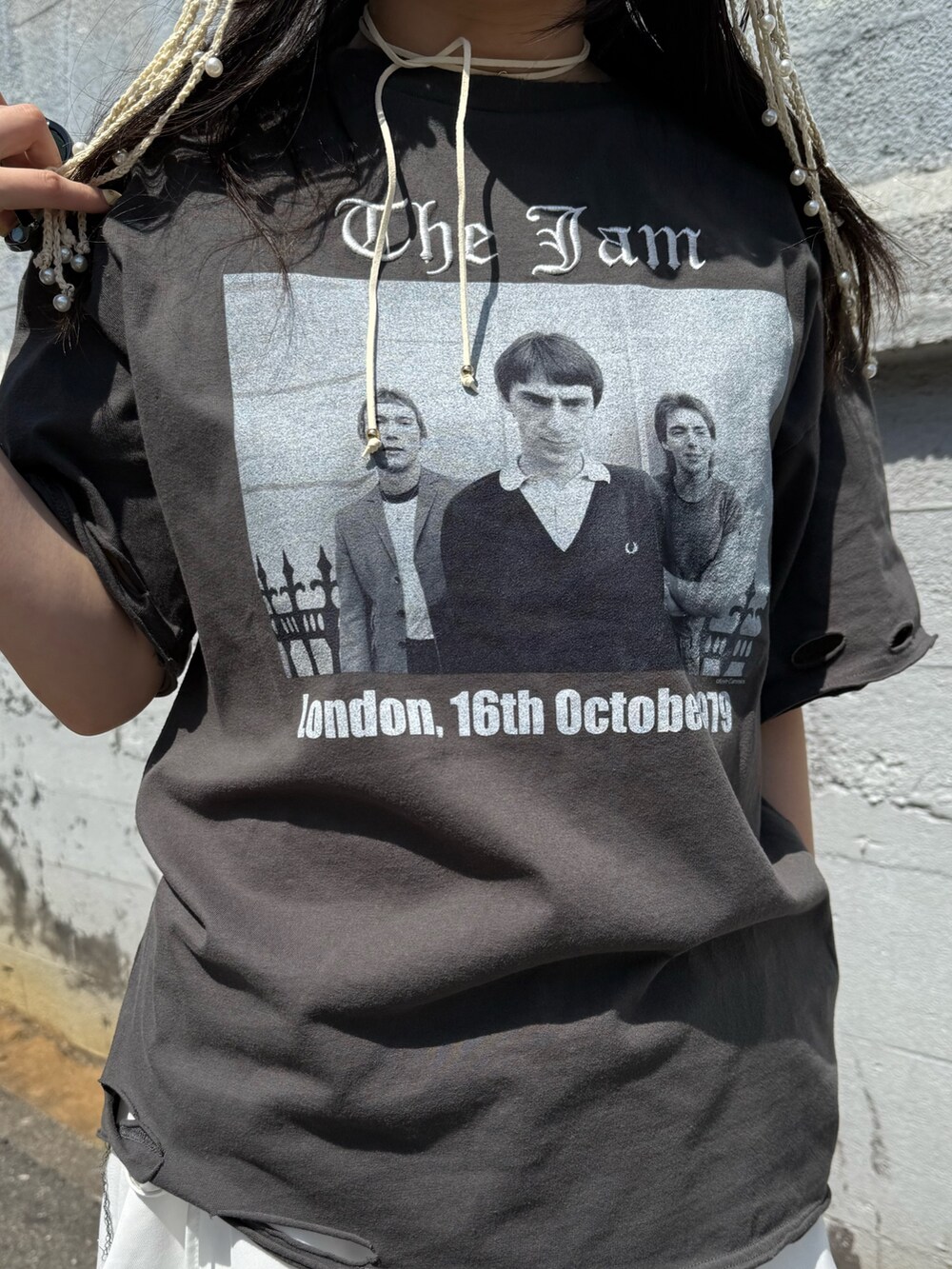 ブラウン系のブーツ、ブラック系のTシャツ/カットソー、ホワイト系のスカートを着用したレディースの春コーディネートの6枚目の写真