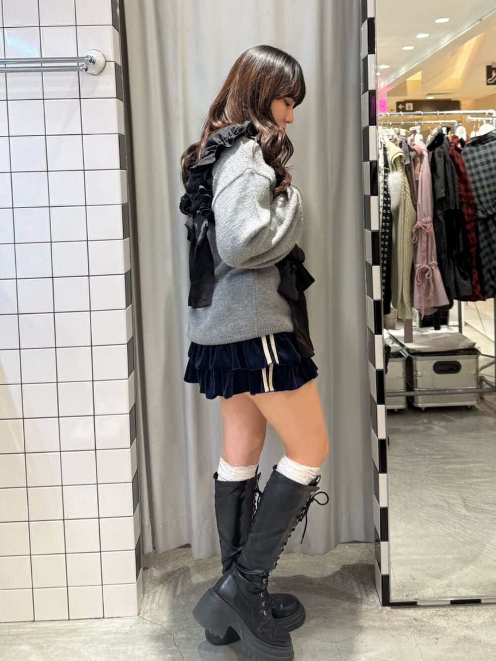 ブルー系のスカート、ブラック系のブーツ、グレー系のニット/セーターを着用したレディースの冬コーディネートの3枚目の写真