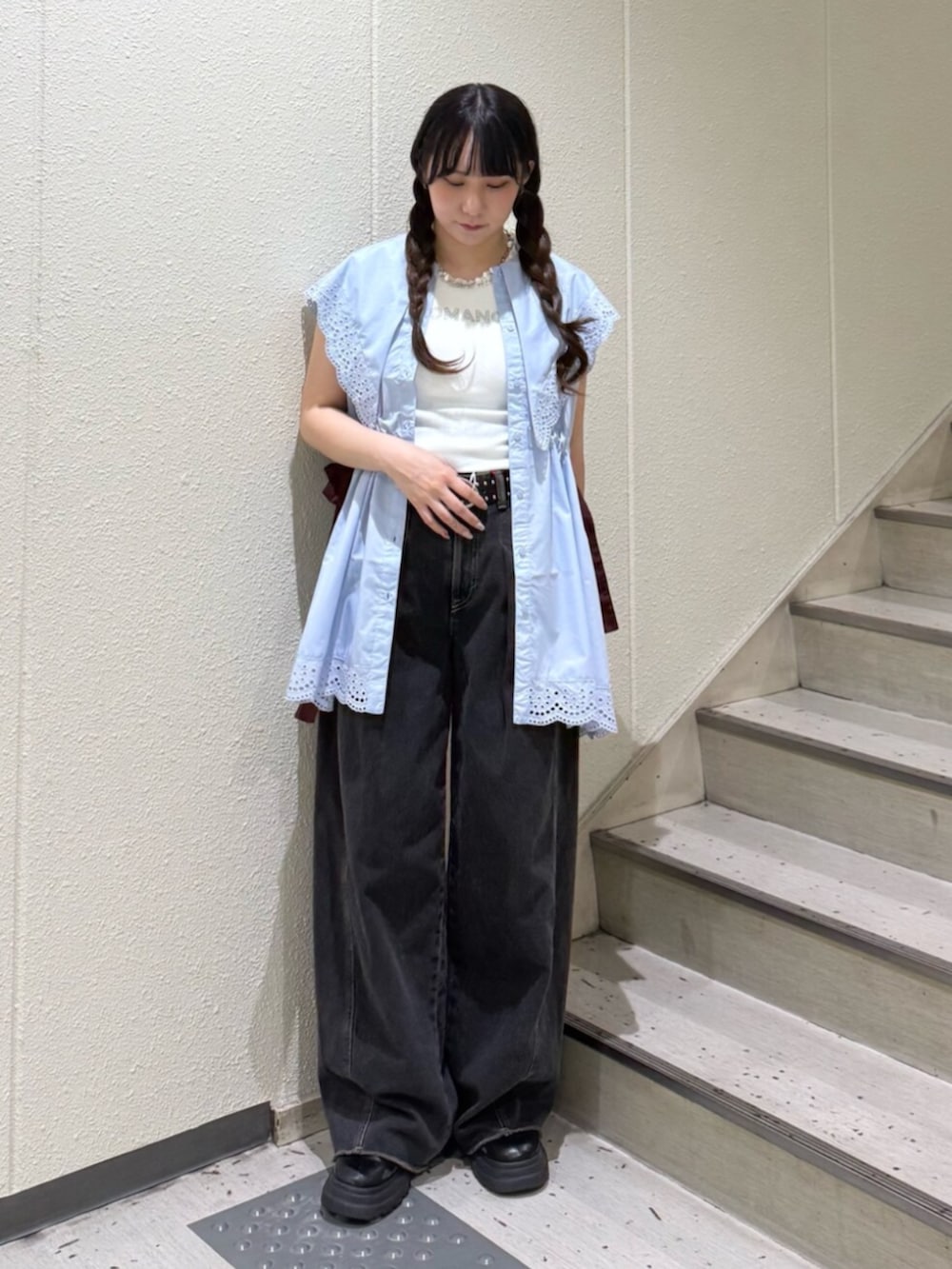 ブラック系のブーツ、ブラック系のデニムパンツ、ホワイト系のタンクトップを着用したレディースの夏コーディネートの4枚目の写真