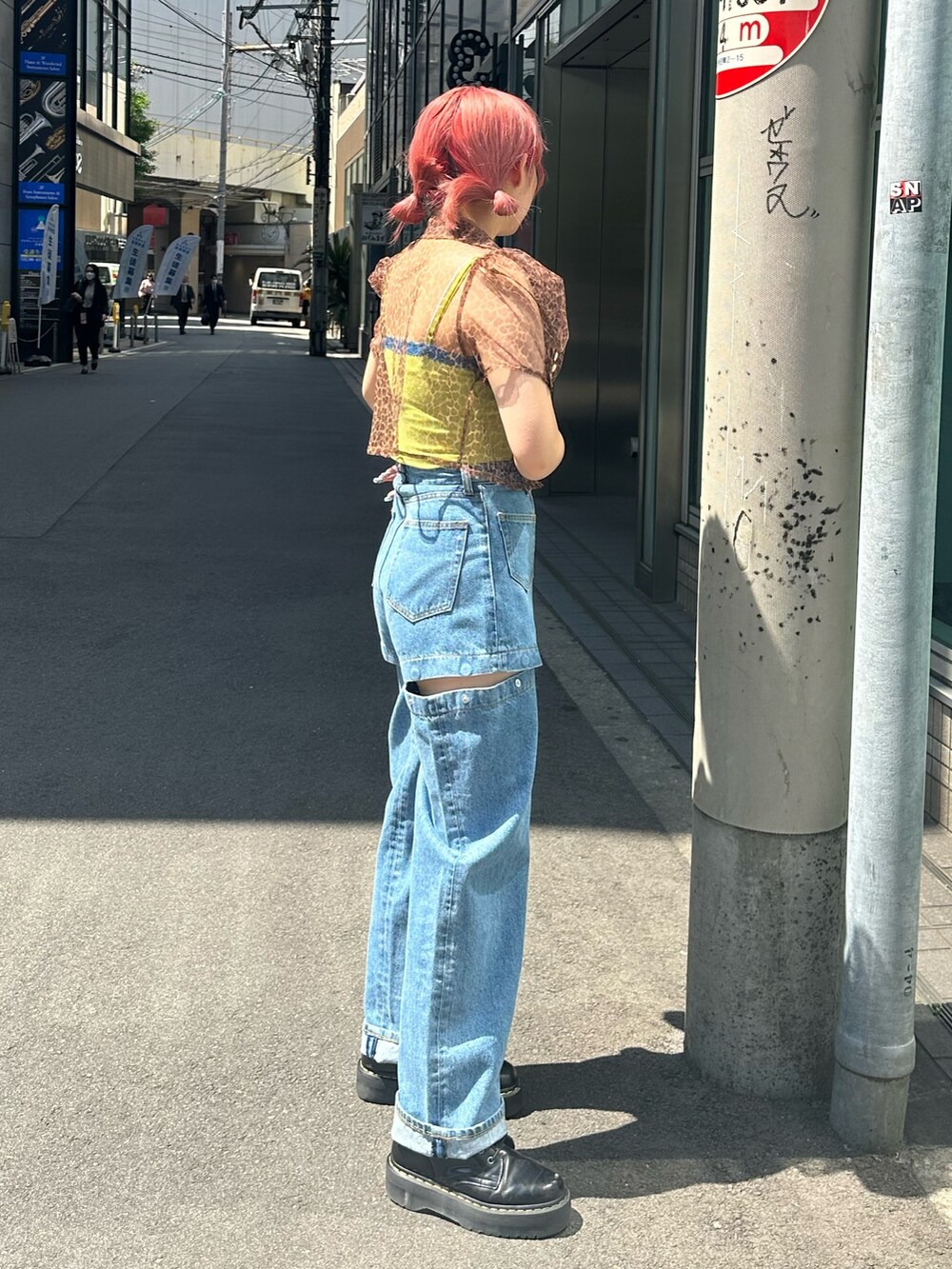 ブラウン系のシャツ/ブラウス、ブルー系のデニムパンツ、ブラック系のブーツを着用したレディースの夏コーディネートの2枚目の写真