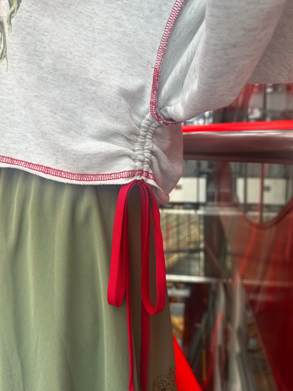 グレー系のスウェット、グリーン系のスカート、ブラック系のショルダーバッグを着用したレディースの夏コーディネートの8枚目の写真