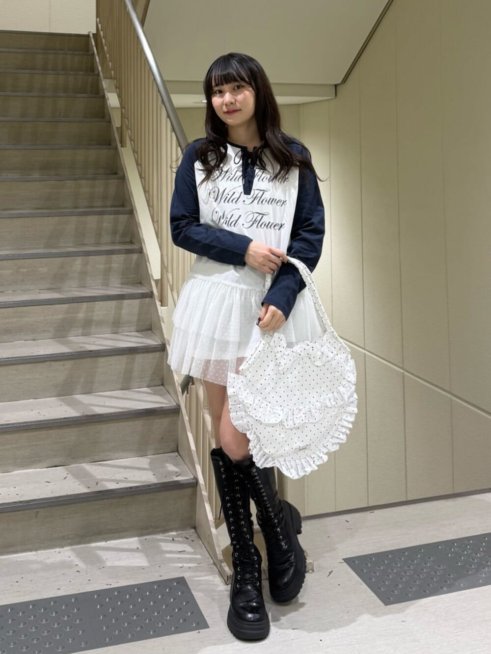 ブラック系のブーツ、ブラウン系のブルゾン、ホワイト系のワンピースを着用したレディースの冬コーディネートの6枚目の写真