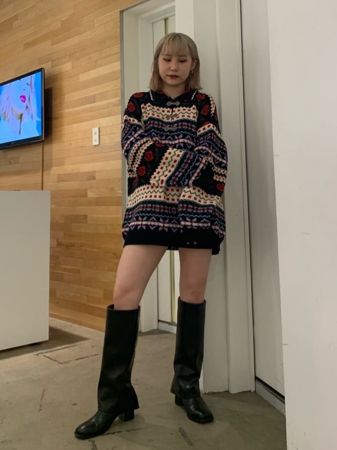 ホワイト系のブーツ、ブラック系のニット/セーターを着用したレディースの秋コーディネートの2枚目の写真