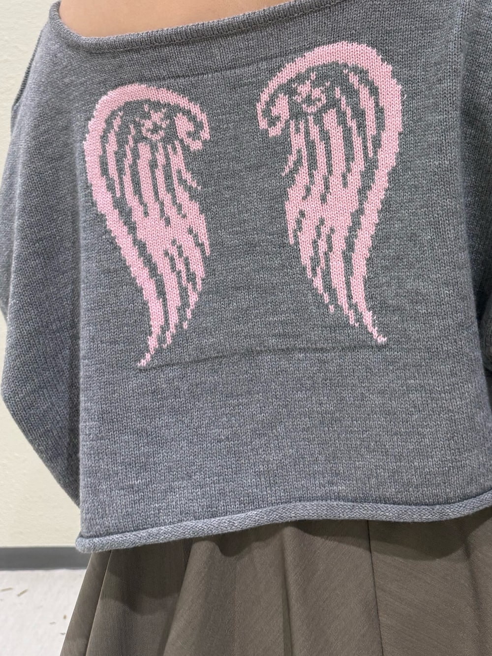 ベージュ系のスカート、グレー系のニット/セーター、ブラック系のブーツを着用したレディースの冬コーディネートの8枚目の写真