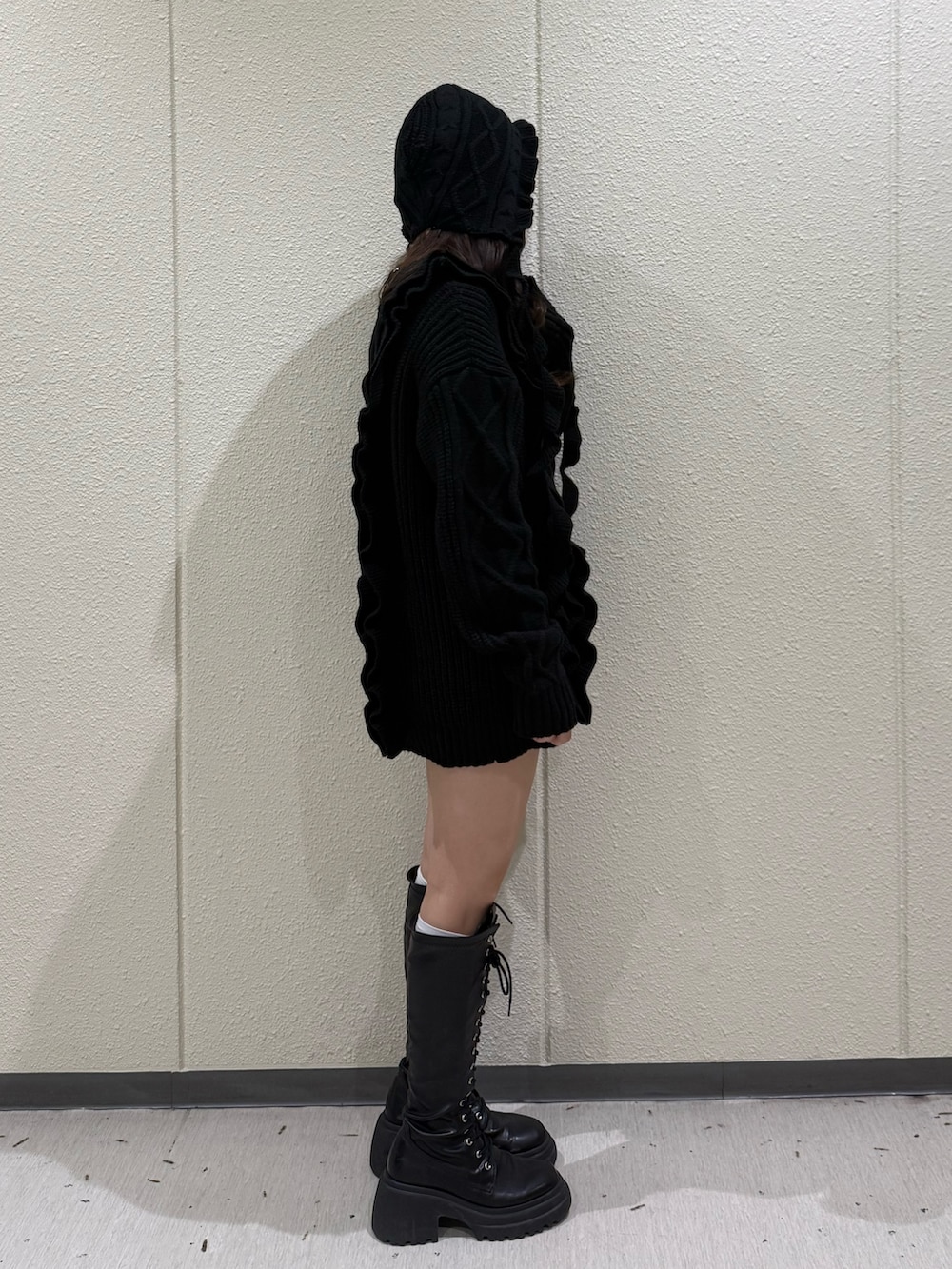 ブラック系のニット/セーター、ブラック系のブーツ、ブラック系のニットキャップ/ビーニーを着用したレディースの冬コーディネートの3枚目の写真