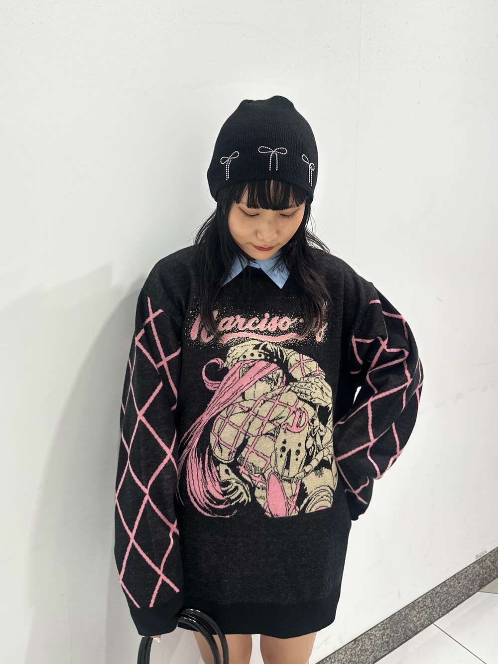 ブラック系のニット/セーター、ブラウン系のブーツ、ブルー系のシャツ/ブラウスを着用したレディースの秋コーディネートの5枚目の写真