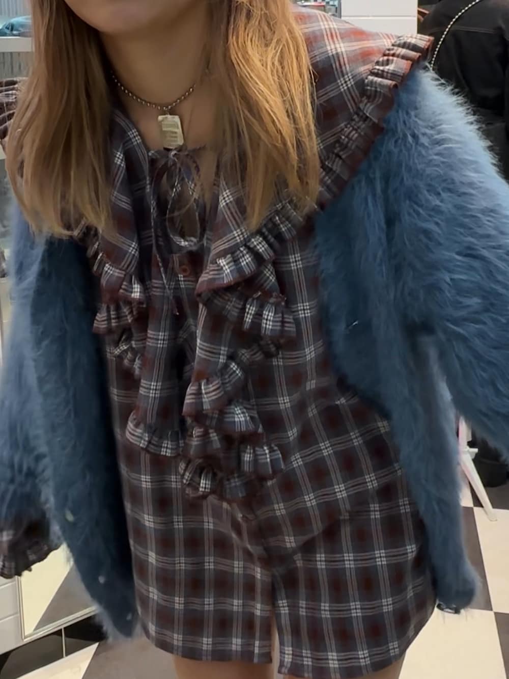 ブラウン系のシャツ/ブラウス、ブルー系のカーディガン/ボレロ、ブラック系のブーツを着用したレディースの秋コーディネートの3枚目の写真