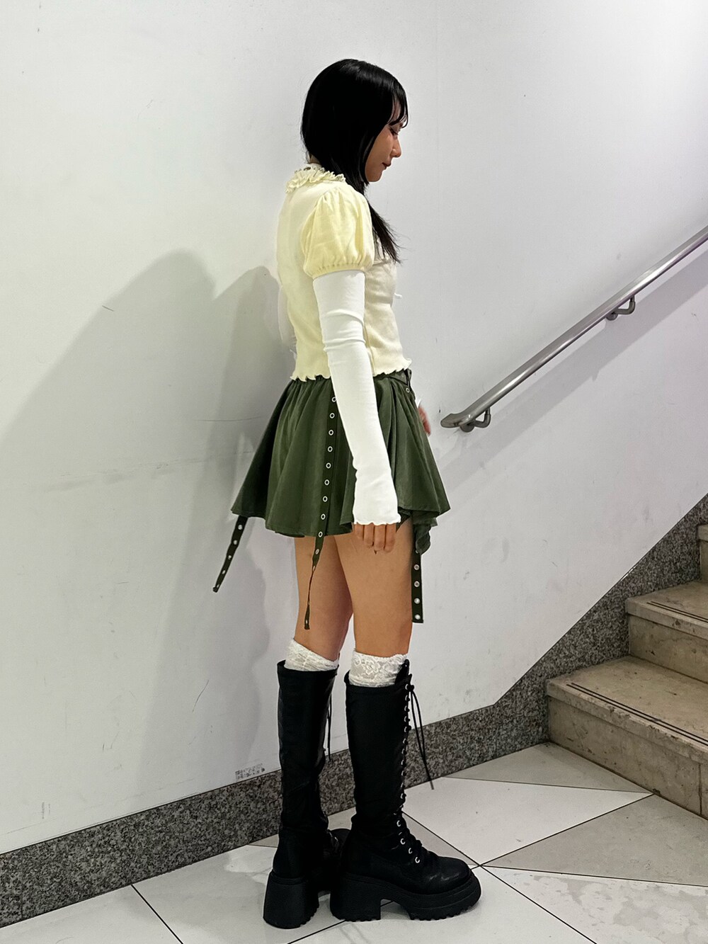 ホワイト系のTシャツ/カットソー、グリーン系のスカート、ブラック系のブーツを着用したレディースの秋コーディネートの3枚目の写真