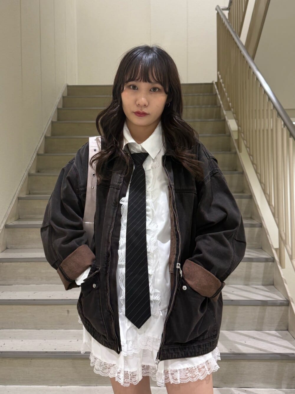 ブラック系のデニムジャケット、ブラック系のブーツ、ホワイト系のシャツ/ブラウスを着用したレディースの秋コーディネートの6枚目の写真