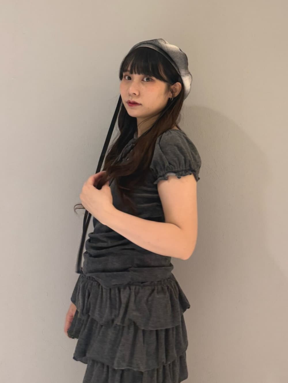 ブラック系のブーツ、グレー系のTシャツ/カットソー、グレー系のスカートを着用したレディースの夏コーディネートの6枚目の写真