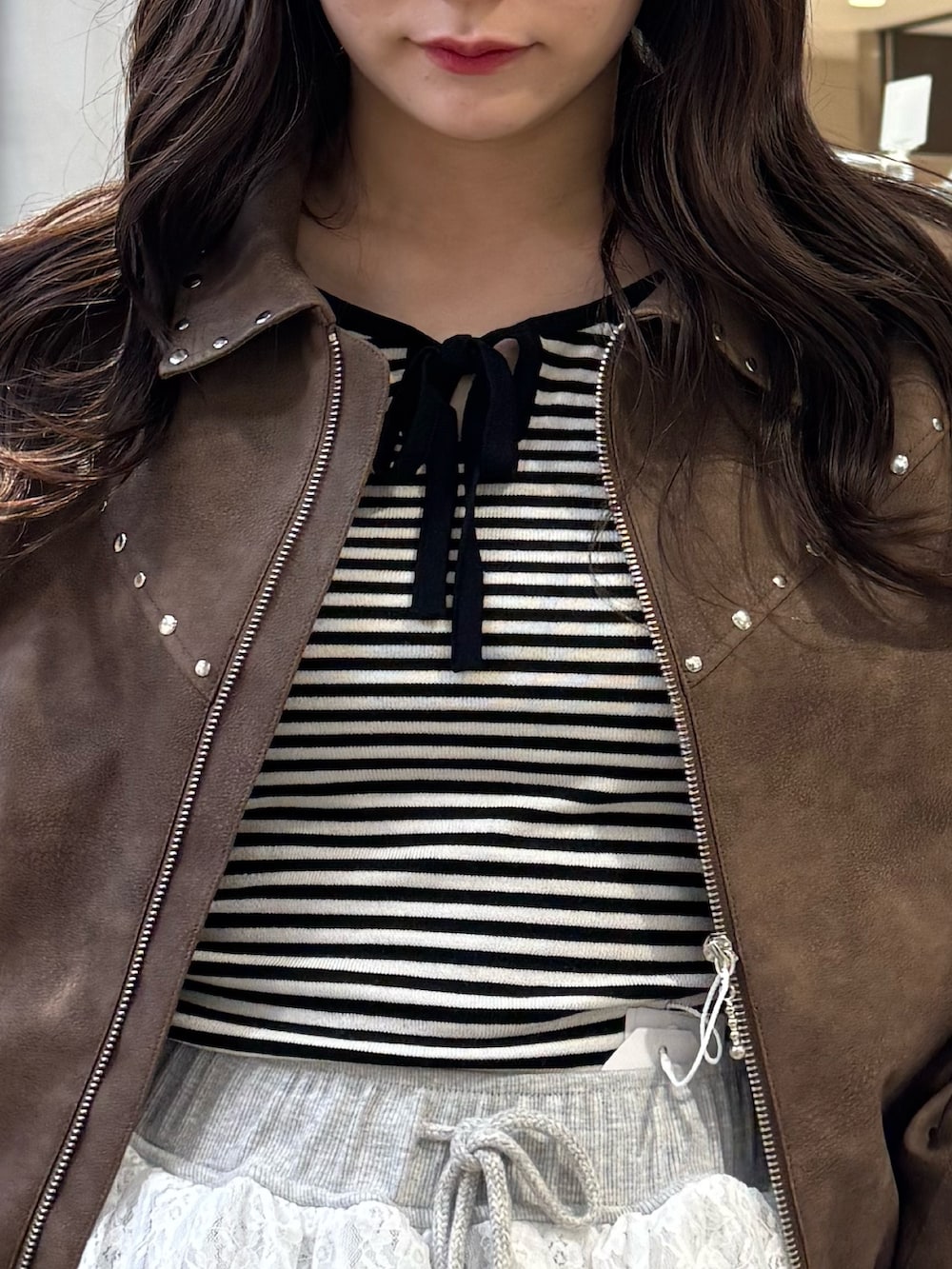 ブラック系のニット/セーター、ブラウン系のブルゾン、グレー系のスウェットパンツを着用したレディースの冬コーディネートの10枚目の写真