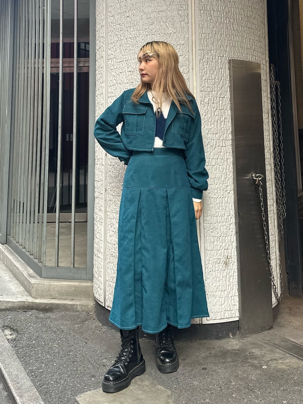 ブルー系のワンピース、ホワイト系のニット/セーター、ゴールド系のネックレスを着用したレディースの秋コーディネートの2枚目の写真