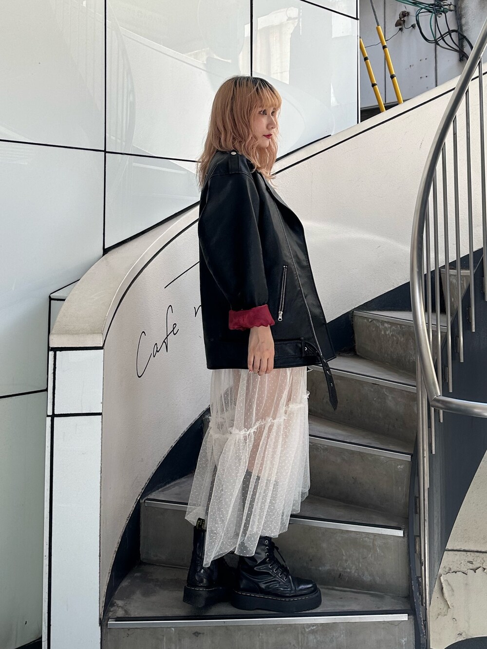 ブラック系のTシャツ/カットソー、ブラック系のライダースジャケット、ホワイト系のワンピースを着用したレディースの夏コーディネートの2枚目の写真