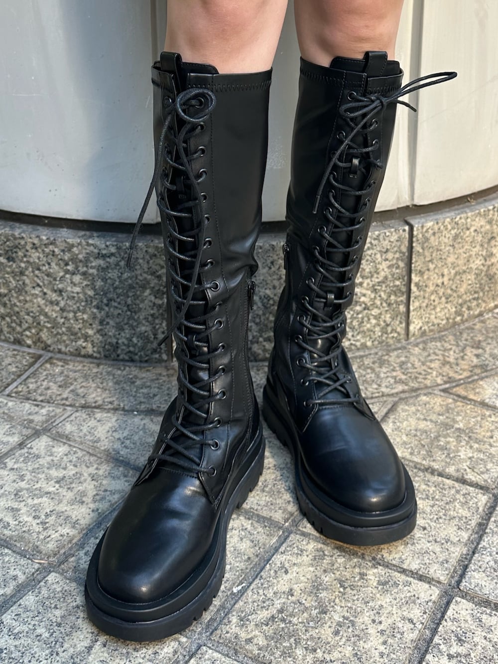 ブラック系のニット/セーター、ブラック系のデニムパンツ、ブラック系のブーツを着用したレディースの冬コーディネートの7枚目の写真