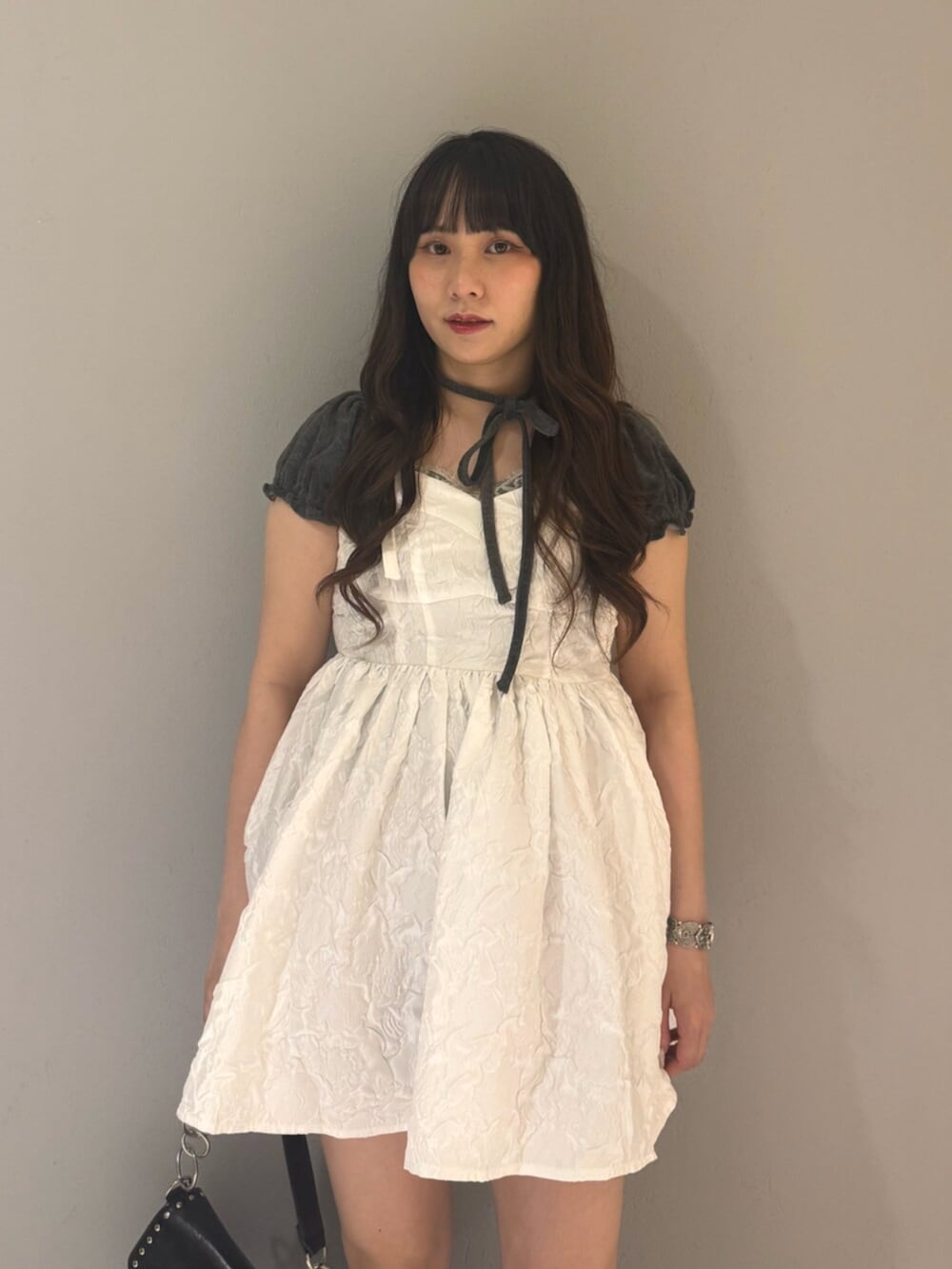 ブラック系のハンドバッグ、ブラック系のブーツ、グレー系のTシャツ/カットソーを着用したレディースの夏コーディネートの5枚目の写真
