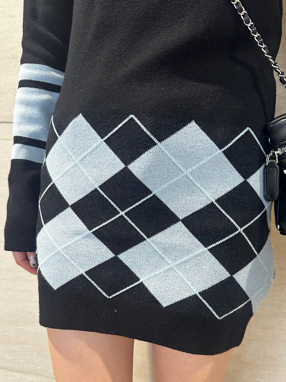 ブラック系のブーツ、ブラック系のワンピース、ブラック系のショルダーバッグを着用したレディースの秋コーディネートの7枚目の写真