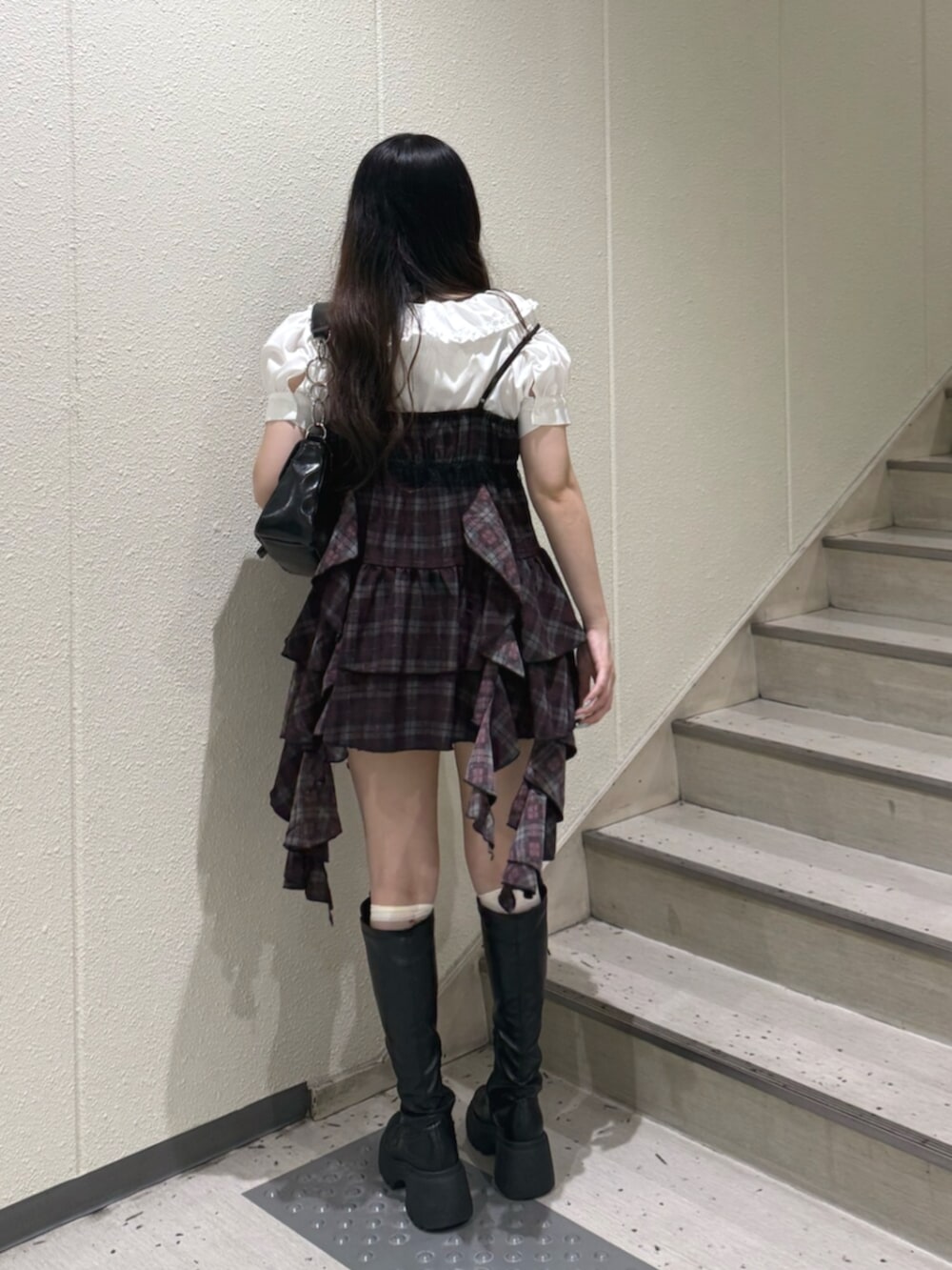 ホワイト系のシャツ/ブラウス、ブラック系のハンドバッグ、ブラック系のブーツを着用したレディースの夏コーディネートの3枚目の写真