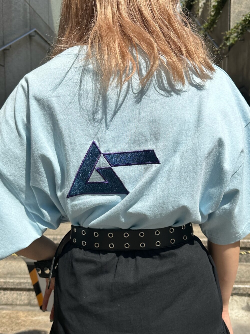 ブルー系のTシャツ/カットソー、ブラック系のショルダーバッグ、ブラック系のスカートを着用したレディースの春コーディネートの5枚目の写真