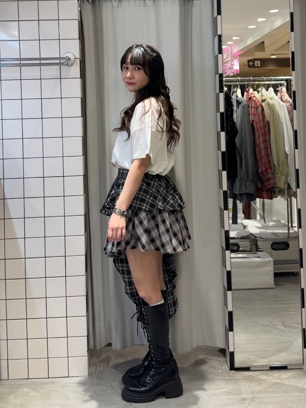 ブラック系のスカート、ブラック系のブーツ、ホワイト系のTシャツ/カットソーを着用したレディースの春コーディネートの3枚目の写真