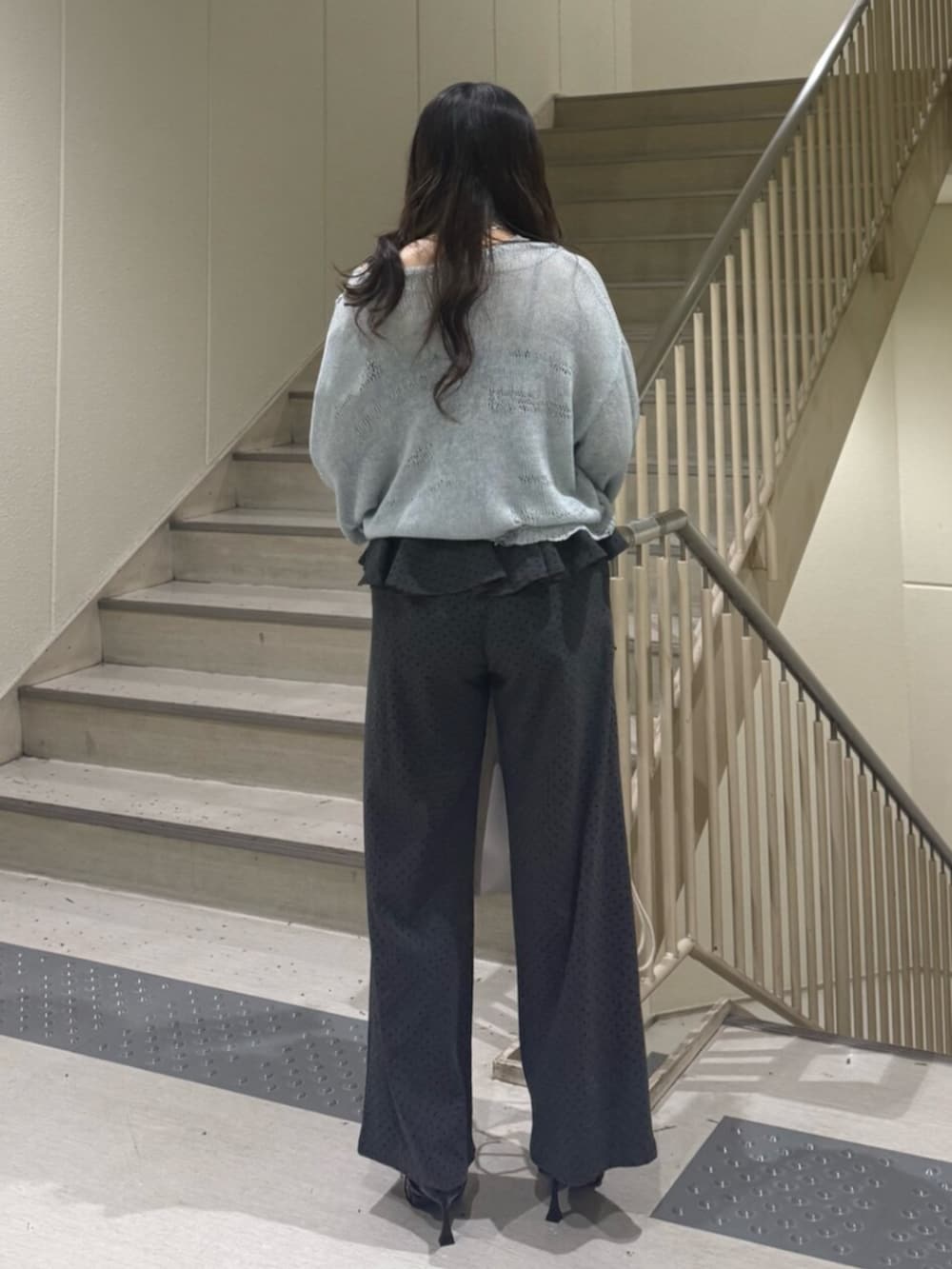 ブルー系のニット/セーター、グレー系のスウェットパンツ、ブラック系のパンプスを着用したレディースの春コーディネートの5枚目の写真