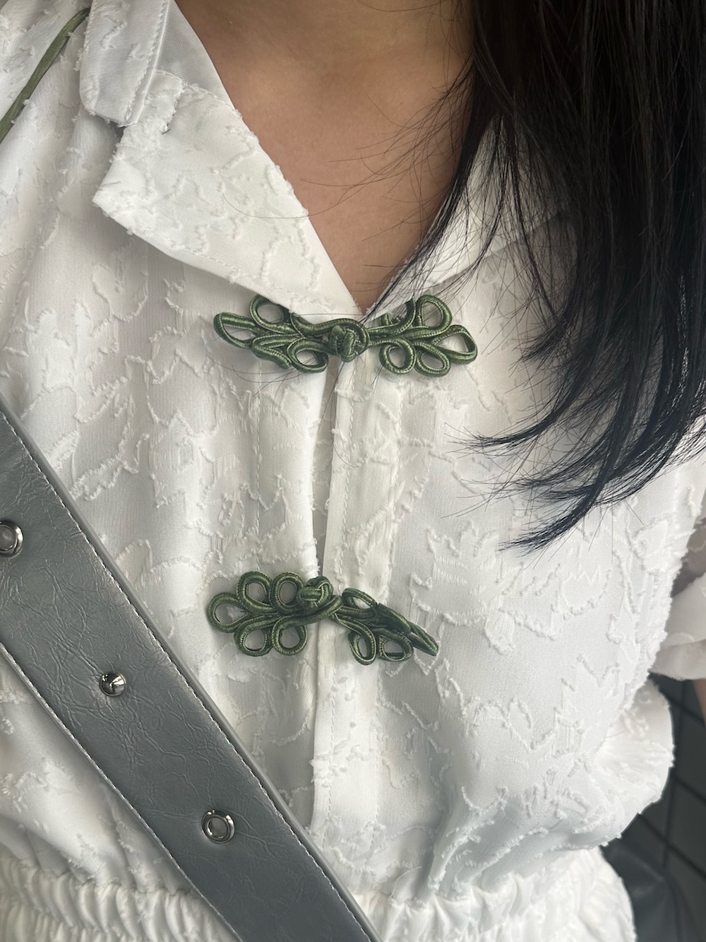 シルバー系のショルダーバッグ、ホワイト系のワンピースを着用したレディースの夏コーディネートの5枚目の写真