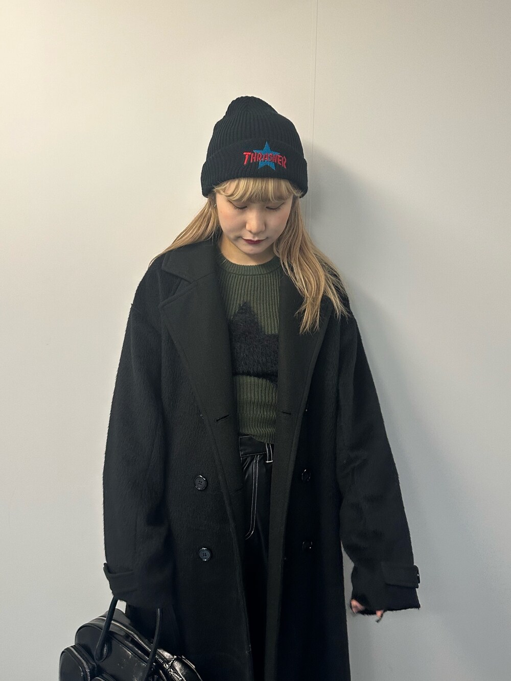 グリーン系のニット/セーター、その他のチェスターコート、ブラック系のボストンバッグを着用したレディースの冬コーディネートの3枚目の写真