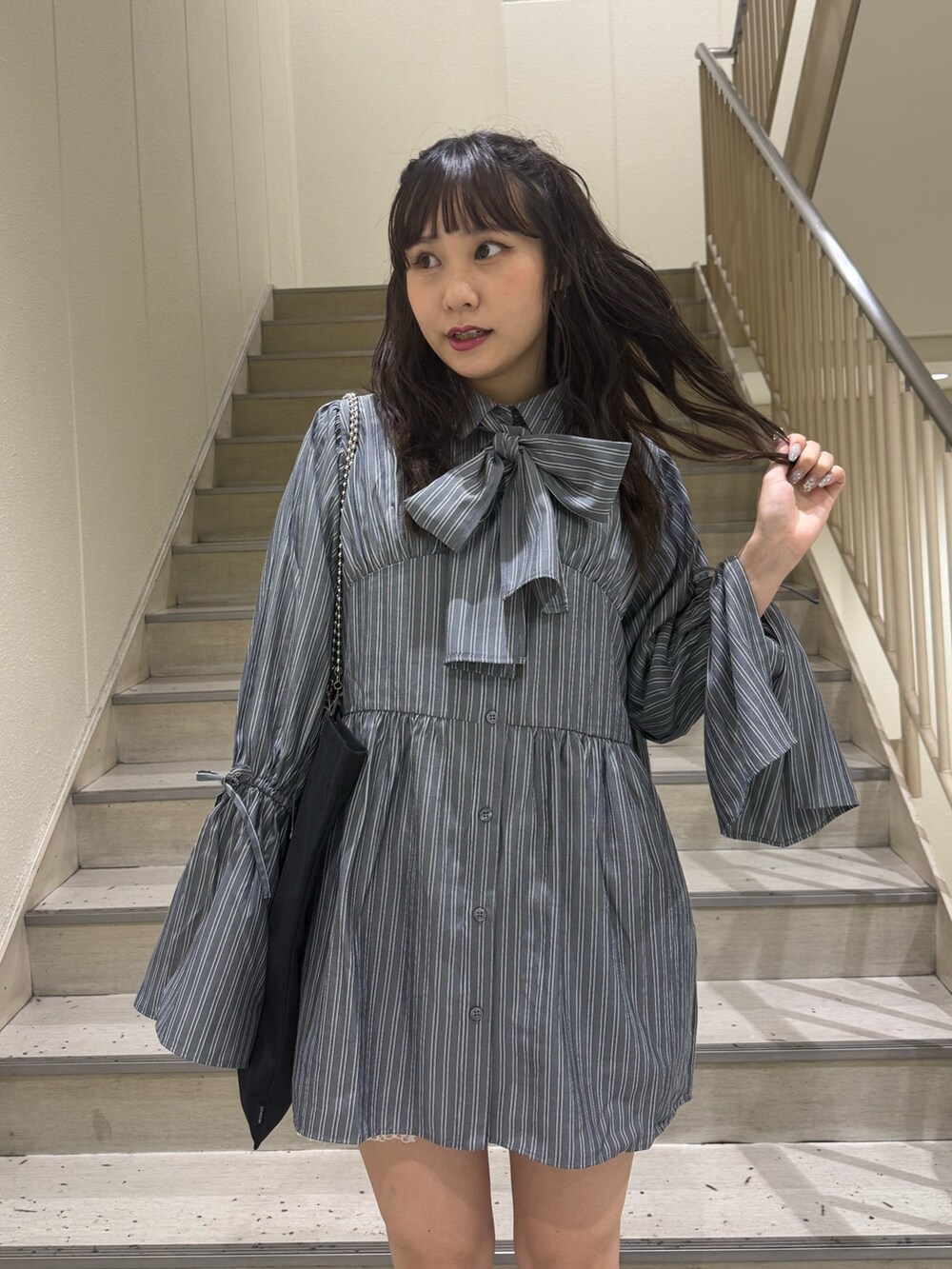 グレー系のシャツ/ブラウス、ブラック系のトートバッグ、ブルー系のブーツを着用したレディースの夏コーディネートの6枚目の写真