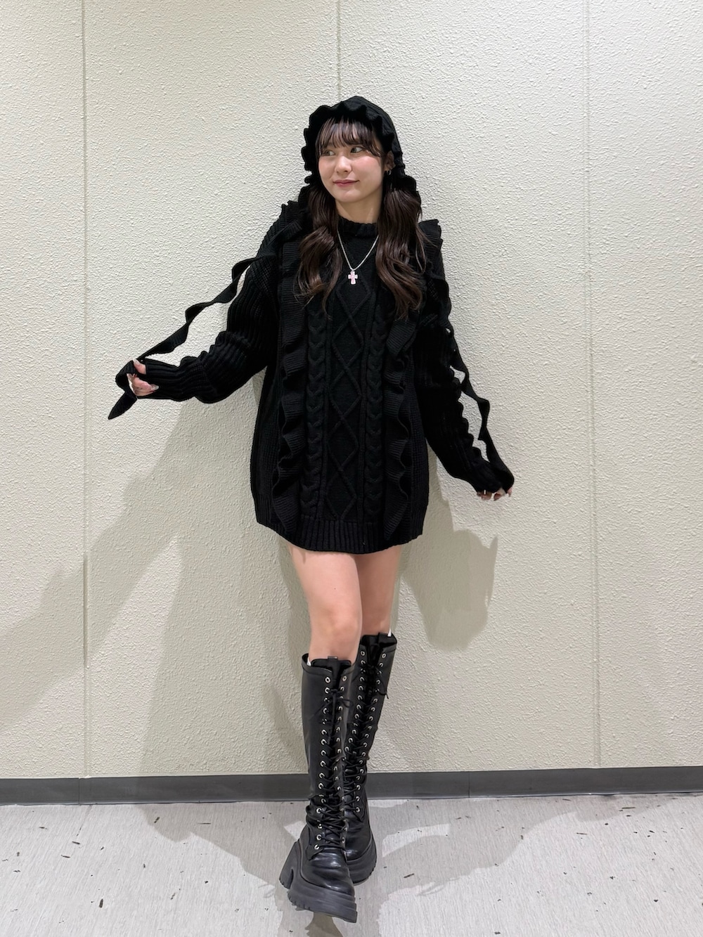 ブラック系のニット/セーター、ブラック系のブーツ、ブラック系のニットキャップ/ビーニーを着用したレディースの冬コーディネートの5枚目の写真