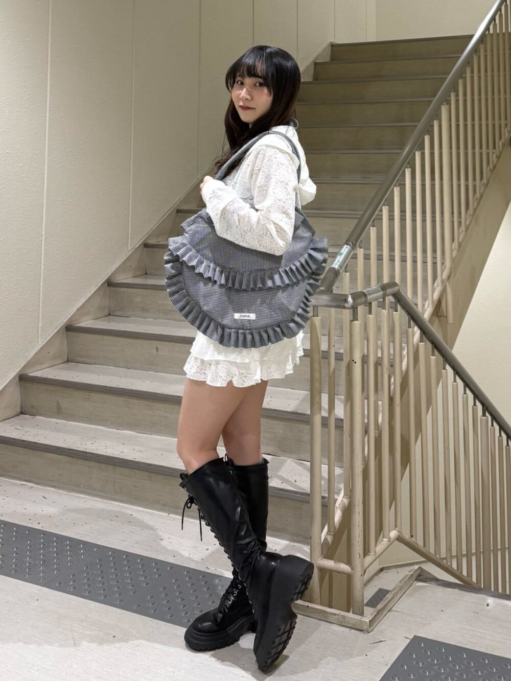 ブラック系のブーツ、ブルー系のキャミソール、ホワイト系のパーカーを着用したレディースの春コーディネートの4枚目の写真