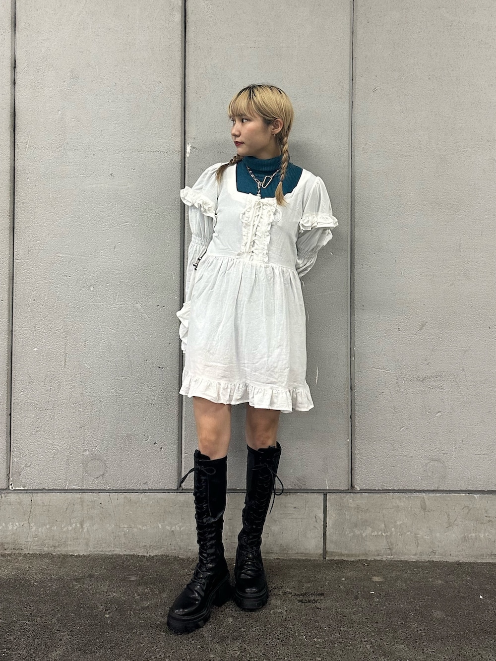 ホワイト系のワンピース、ブラック系のブーツ、ブルー系のニット/セーターを着用したレディースの秋コーディネートの2枚目の写真