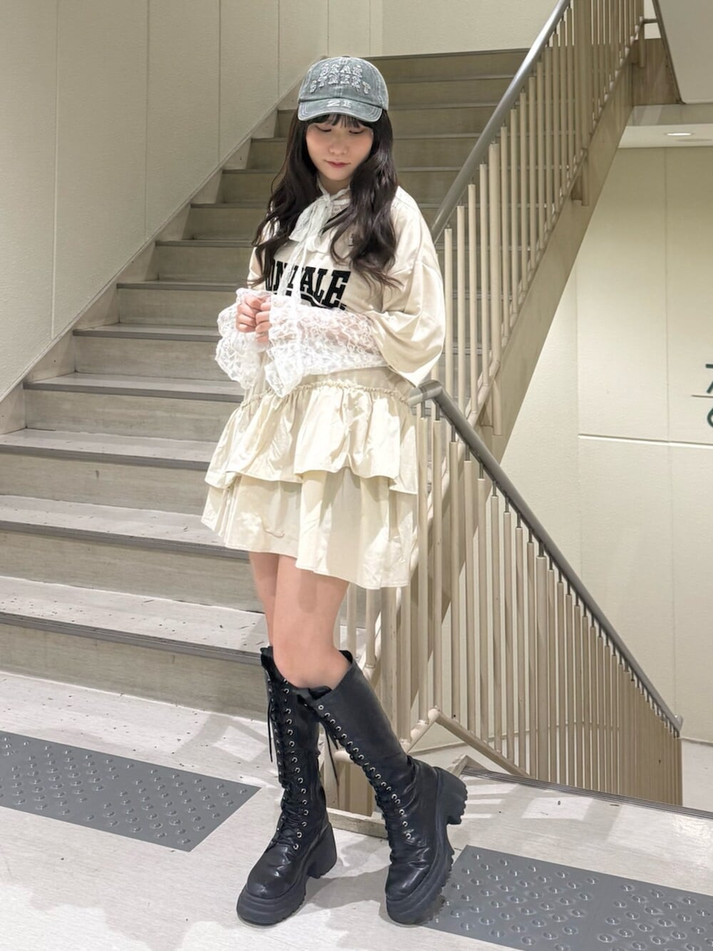 ブラック系のブーツ、ホワイト系のワンピース、ホワイト系のTシャツ/カットソーを着用したレディースの春コーディネートの6枚目の写真