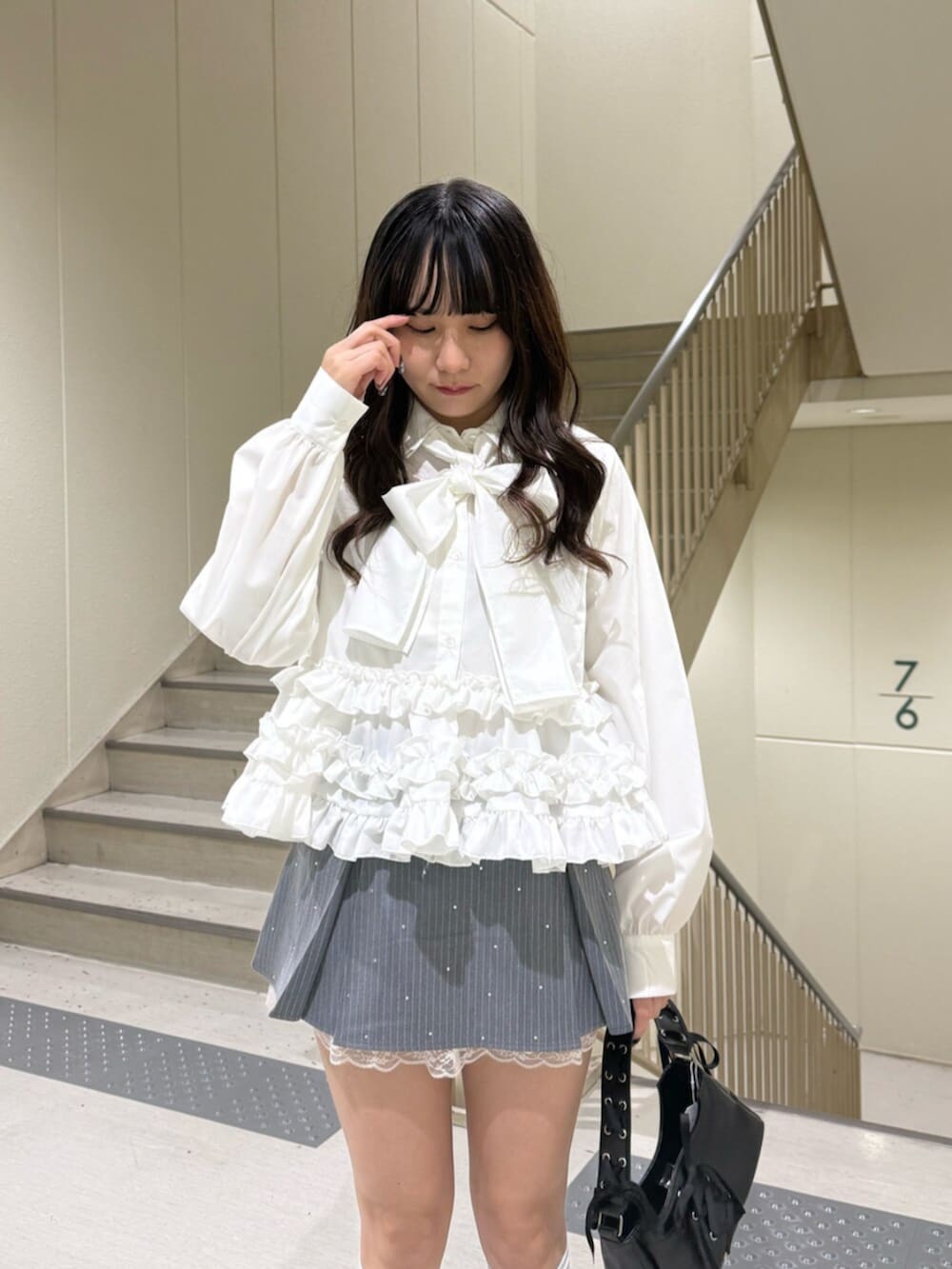 ブラック系のハンドバッグ、ブラック系のローファー、グレー系のスカートを着用したレディースの冬コーディネートの8枚目の写真