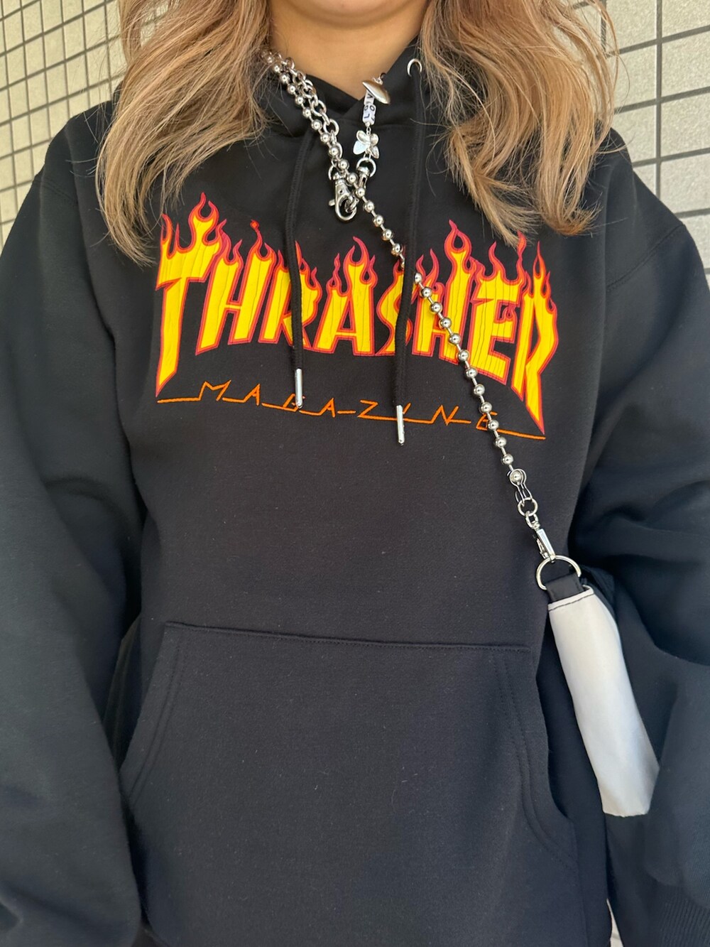 レッド系のスカート、ブラック系のパーカー、ブラック系のハンドバッグを着用したレディースの秋コーディネートの6枚目の写真