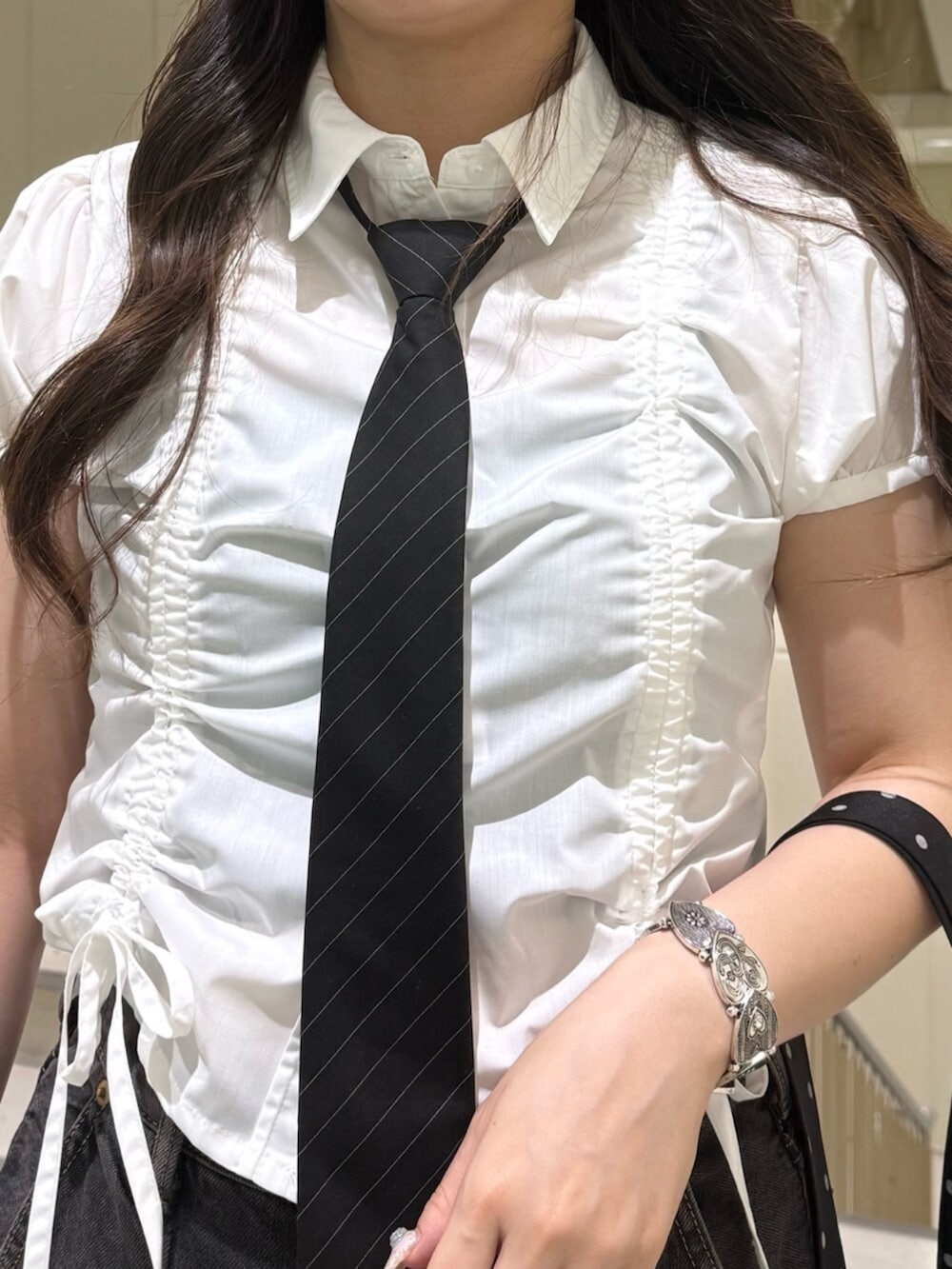 ブラック系のネクタイ、ブラック系のブーツ、ブラック系のデニムパンツを着用したレディースの夏コーディネートの8枚目の写真