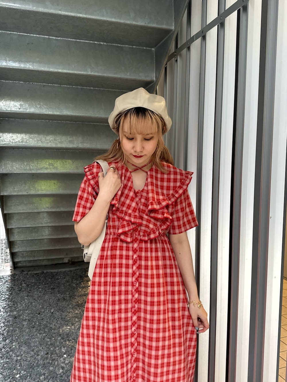 レッド系のワンピース、ホワイト系のショルダーバッグ、ホワイト系のハンチング/ベレー帽を着用したレディースの春コーディネートの3枚目の写真