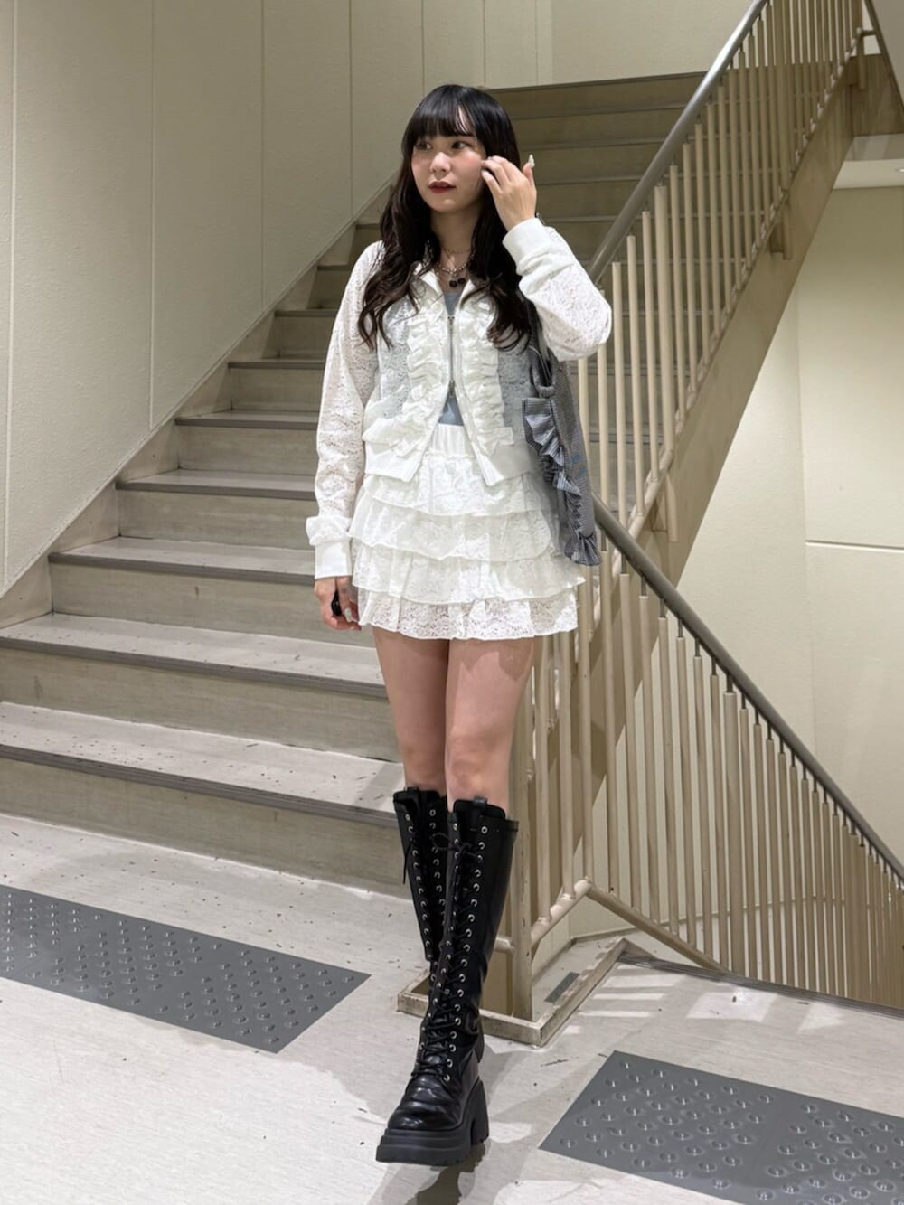 ブラック系のブーツ、ブルー系のキャミソール、ホワイト系のパーカーを着用したレディースの春コーディネートの3枚目の写真