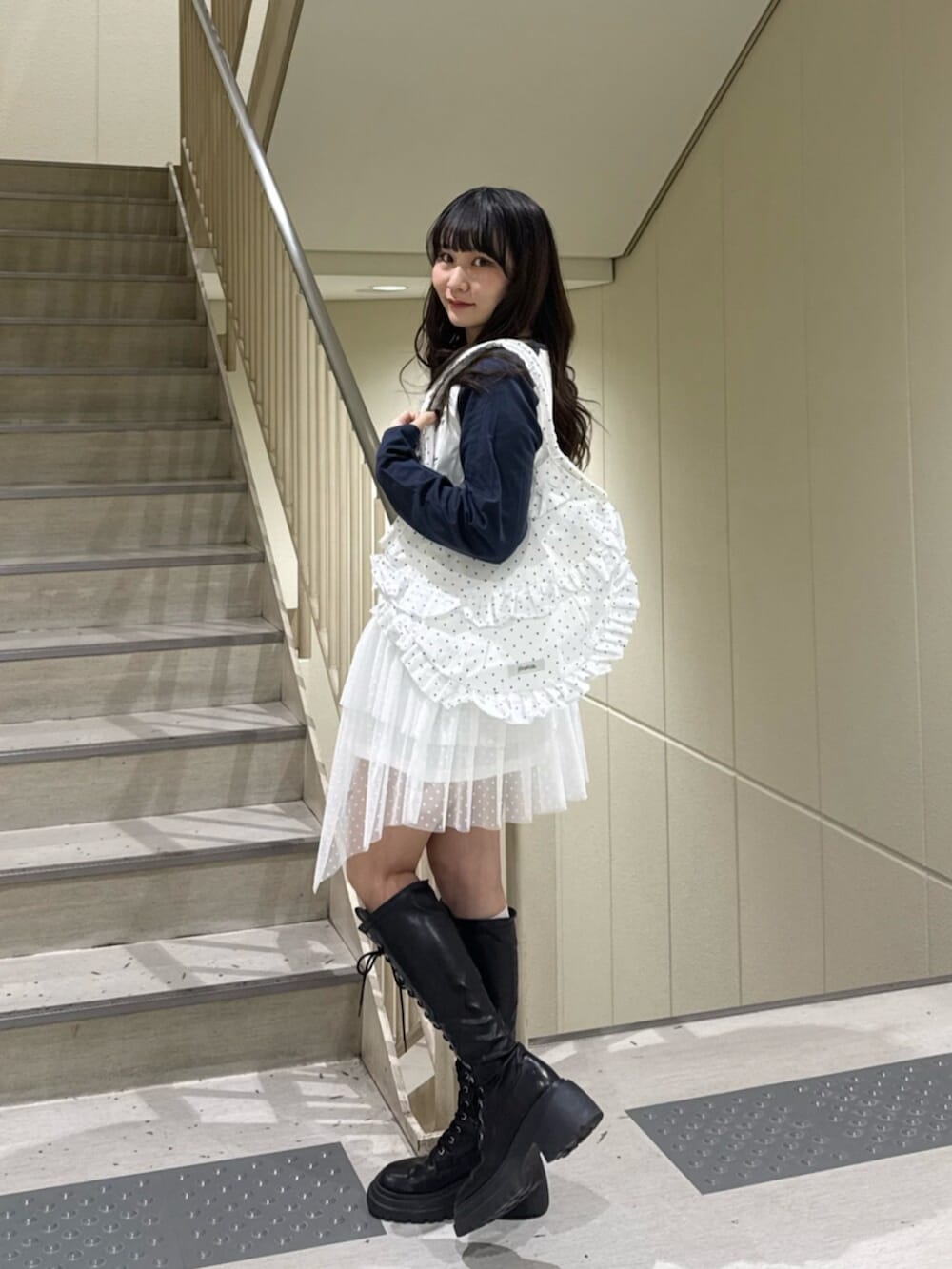 ブラック系のブーツ、ブラウン系のブルゾン、ホワイト系のワンピースを着用したレディースの冬コーディネートの7枚目の写真