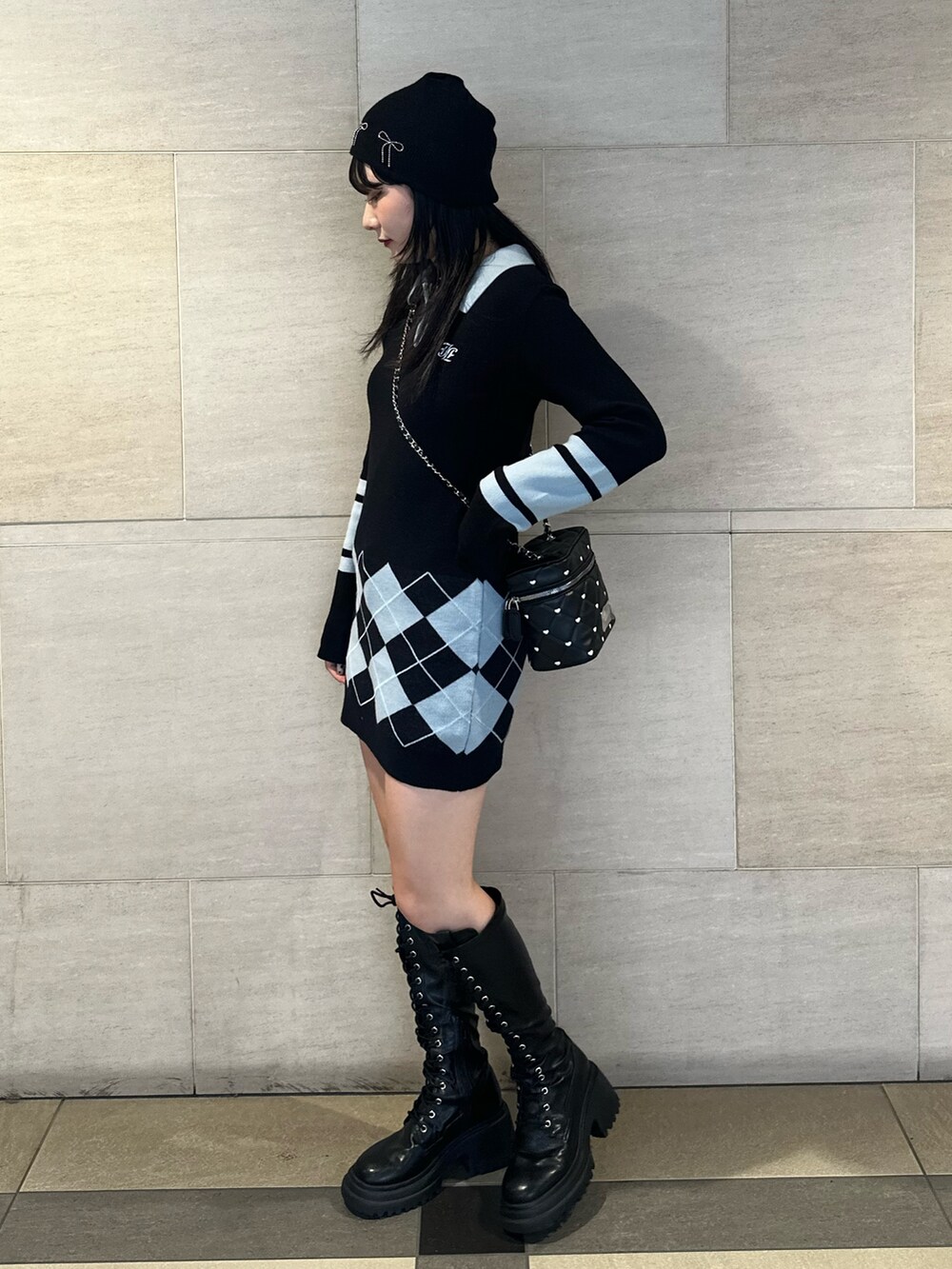 ブラック系のブーツ、ブラック系のワンピース、ブラック系のショルダーバッグを着用したレディースの秋コーディネートの2枚目の写真