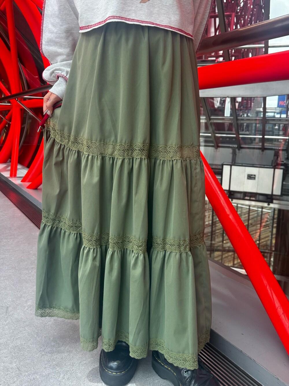 グレー系のスウェット、グリーン系のスカート、ブラック系のショルダーバッグを着用したレディースの夏コーディネートの9枚目の写真