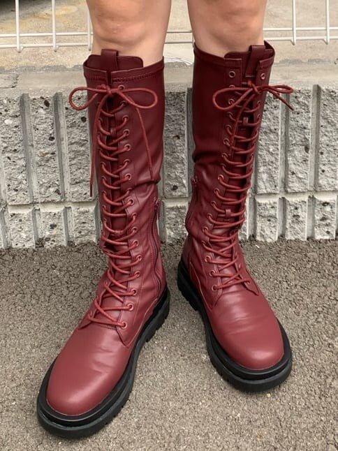 ブルー系のニット/セーター、レッド系のブーツを着用したレディースの秋コーディネートの6枚目の写真