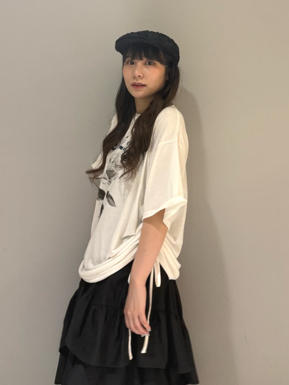 ブラック系のブーツ、ホワイト系のTシャツ/カットソー、ブラック系のスカートを着用したレディースの夏コーディネートの6枚目の写真