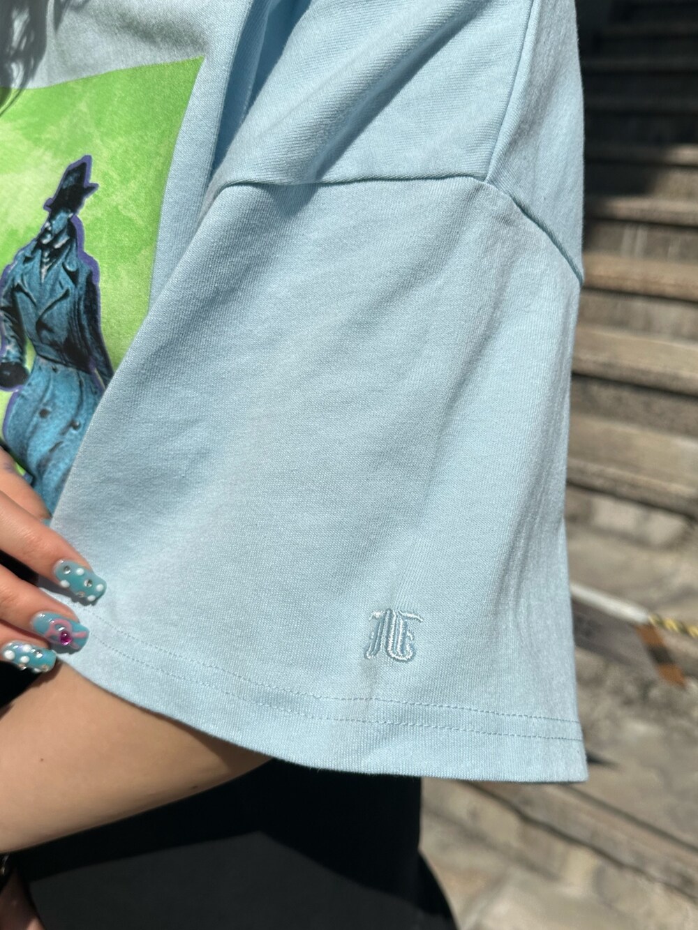 ブルー系のTシャツ/カットソー、ブラック系のショルダーバッグ、ブラック系のスカートを着用したレディースの春コーディネートの8枚目の写真