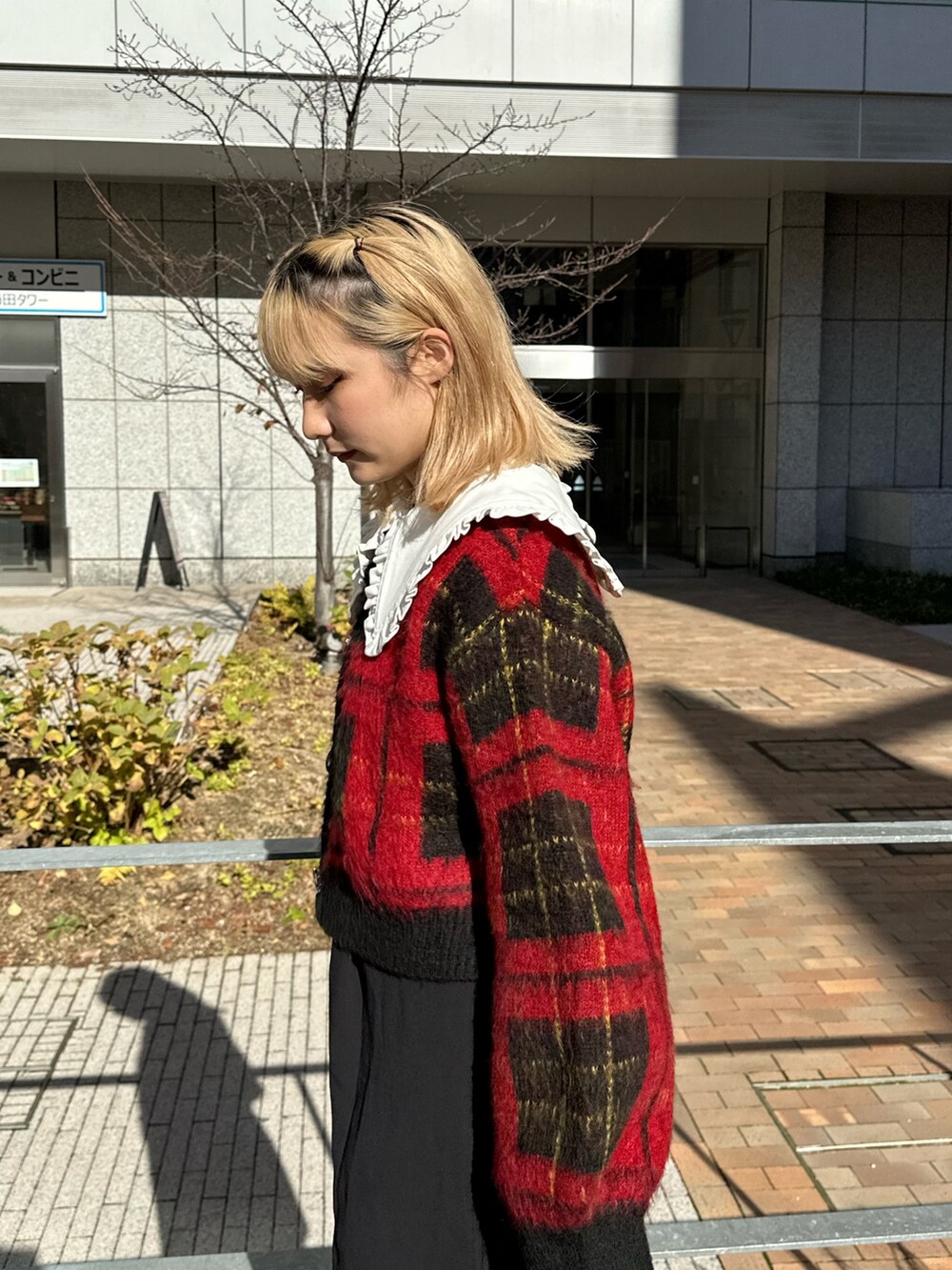 レッド系のカーディガン/ボレロ、ブラック系のワンピース、ブラック系のブーツを着用したレディースの冬コーディネートの4枚目の写真