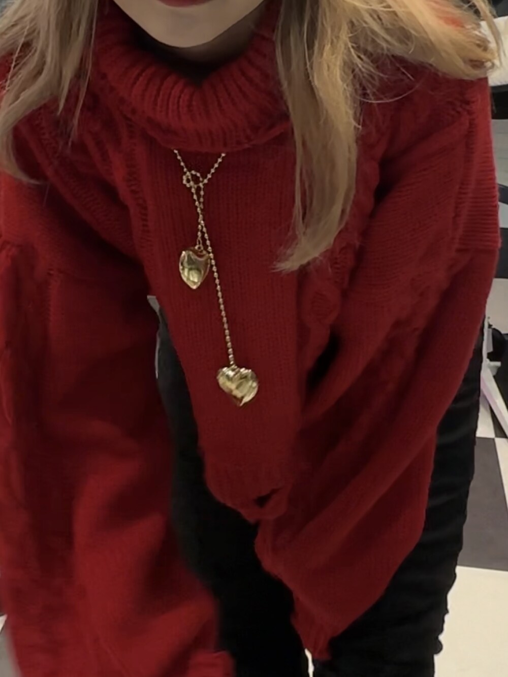 レッド系のニット/セーター、ブラック系のその他パンツ、ゴールド系のネックレスを着用したレディースの秋コーディネートの3枚目の写真