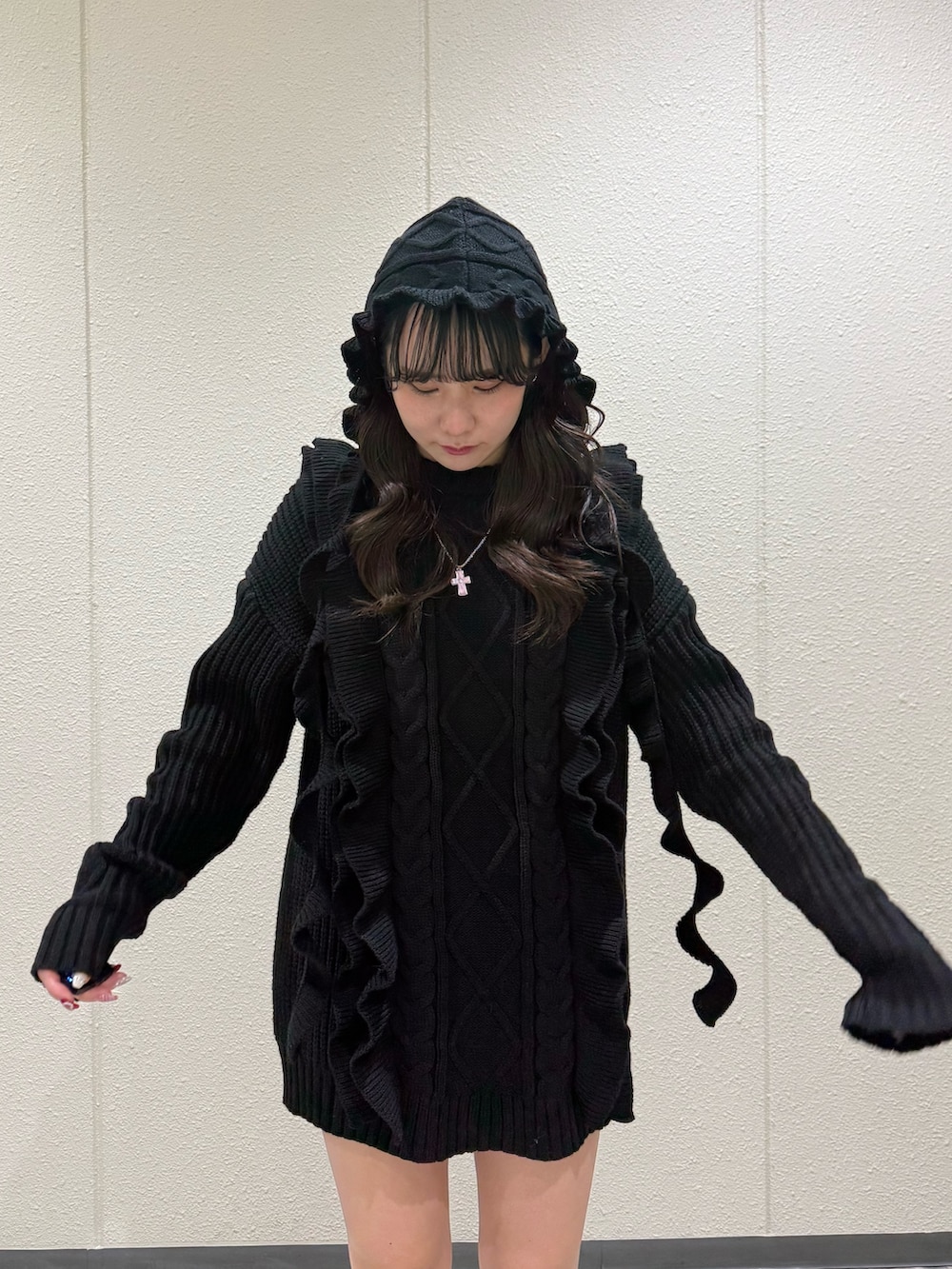 ブラック系のニット/セーター、ブラック系のブーツ、ブラック系のニットキャップ/ビーニーを着用したレディースの冬コーディネートの6枚目の写真